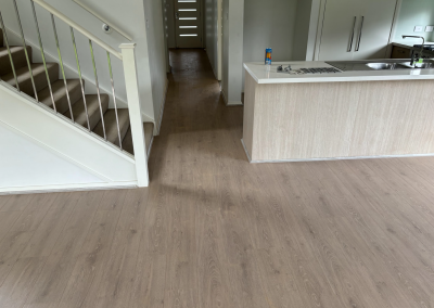 Laminate flooring around the kitchen island and staircase of a Schofields home, Sydney