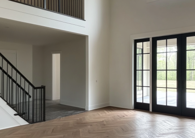 Engineered herringbone flooring in a double-height Rose Bay living space with black stair balustrade, Sydney