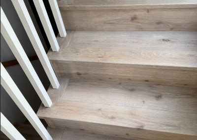 Laminate stair flooring with a white timber balustrade in an Oatley home, Sydney