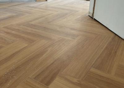 Laminate herringbone flooring finished along a wall in George Hall, Sydney