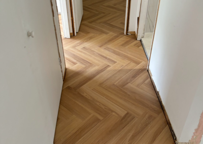 Laminate herringbone flooring carried through a doorway in George Hall, Sydney