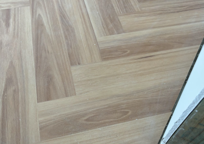 Laminate herringbone flooring in a bright room with floor to ceiling glass, George Hall Sydney
