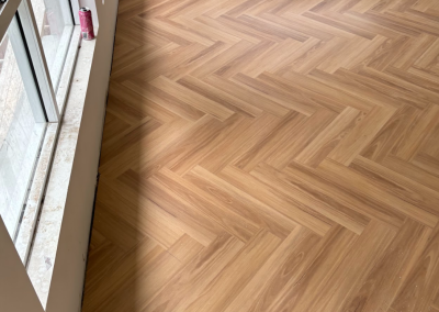 Warm-toned laminate herringbone flooring in a George Hall home, Sydney