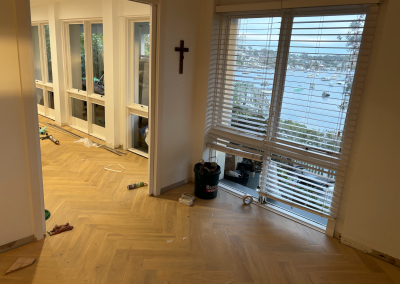 Laminate herringbone flooring being installed in a room with French doors, Burraneer Sydney