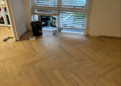 Laminate herringbone flooring being laid at a bay window, Burraneer Sydney