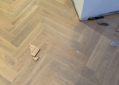 Grey-toned laminate herringbone flooring part-way through installation, Burraneer Sydney