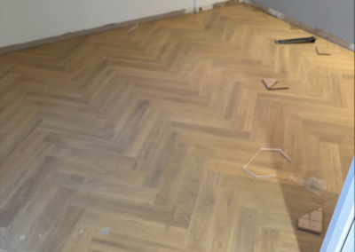 Wide view of grey laminate herringbone flooring in a Burraneer home, Sydney