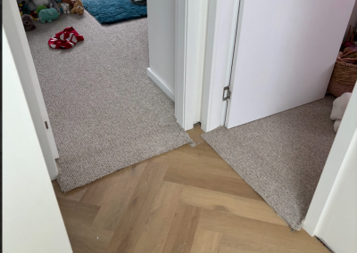 Laminate herringbone flooring meeting carpet at a bedroom doorway in Bangor, Sydney