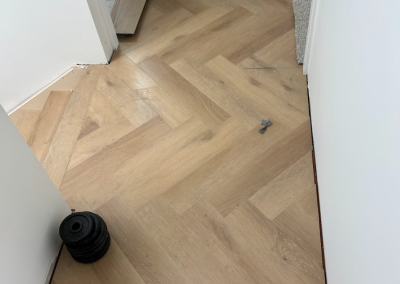 Laminate herringbone flooring finished neatly against skirting and doorway, Bangor Sydney